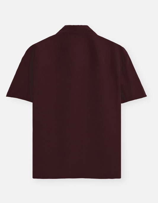Color_Maroon. Premium unisex oversized button-down shirt with a wide, boxy fit and dropped shoulders. Made from breathable solid-colored cotton. Features a structured collar and longline hem, perfect for layered streetwear or minimalist smart-casual outfits.