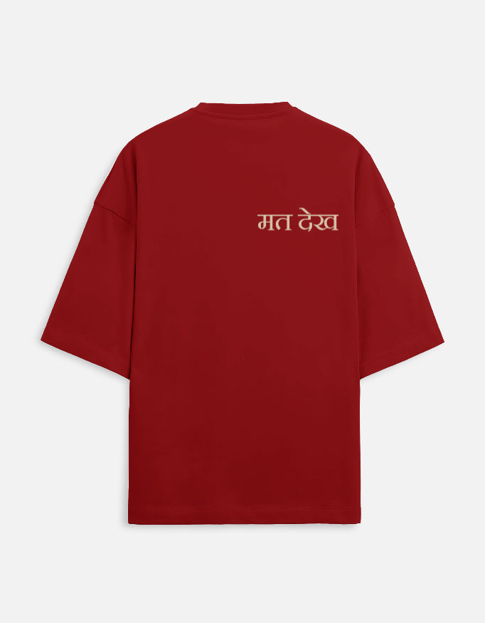 Deep maroon oversized unisex t-shirt with a dual-sided graphic. The front features the Hindi text "Dekh Lunga" (I will handle it) in light gray. The back features the Hindi text "मत देख" (Mat Dekh - Don't look) in light gold, positioned on the upper center. Boxy fit, typographic statement apparel.