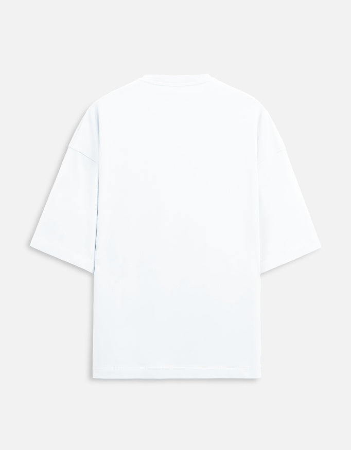 Color_White. versized unisex t-shirt featuring a centered, small graphic of the word "Aalasya" (laziness) written in red, stylized text with a red strikethrough line, signifying "No Laziness." Soft cotton, drop-shoulder, boxy casual apparel with ironic or statement typography.