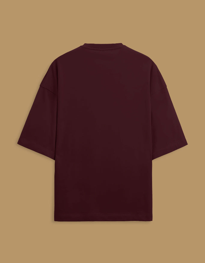 Color_Maroon. Oversized white streetwear t-shirt featuring a centered rectangular graphic of a classical South Asian miniature painting with an orange border. Dropped shoulders, heavyweight cotton, boxy fit.