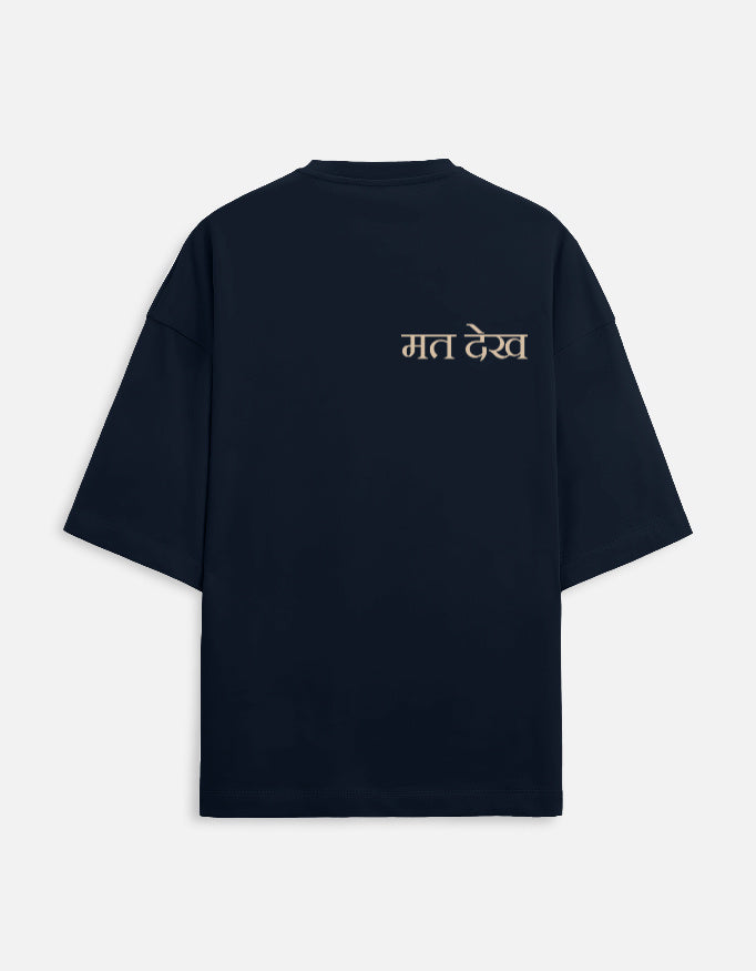 Navy Blue oversized unisex t-shirt with a dual-sided graphic. The front features the Hindi text "Dekh Lunga" (I will handle it) in light gray. The back features the Hindi text "मत देख" (Mat Dekh - Don't look) in light gold, positioned on the upper center. Boxy fit, typographic statement apparel.