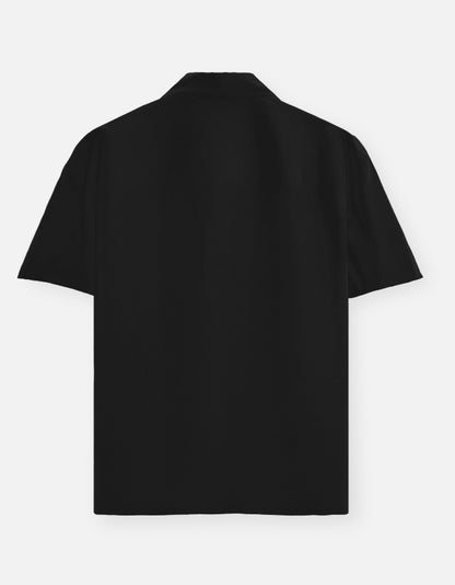 Color_Black. Classic long-sleeved button-down shirt in a solid premium cotton fabric. Features a structured collar, adjustable cuffs, and a regular fit designed for a versatile unisex silhouette. Ideal for smart-casual styling and layering.