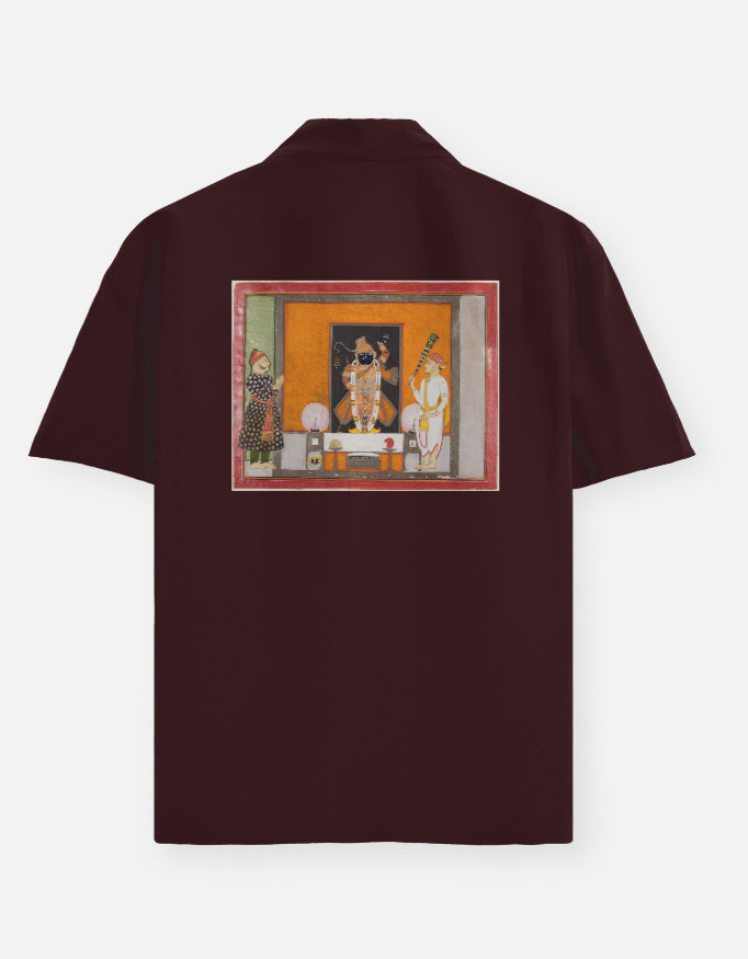 Color_Maroon. Deep burgundy short-sleeve button-down shirt featuring a centered chest graphic of the Matsya avatar. Premium lightweight fabric with a camp collar and relaxed silhouette. Iconic heritage-inspired streetwear.