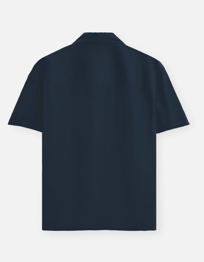 Color_NavyBlue. Premium unisex oversized button-down shirt with a wide, boxy fit and dropped shoulders. Made from breathable solid-colored cotton. Features a structured collar and longline hem, perfect for layered streetwear or minimalist smart-casual outfits.