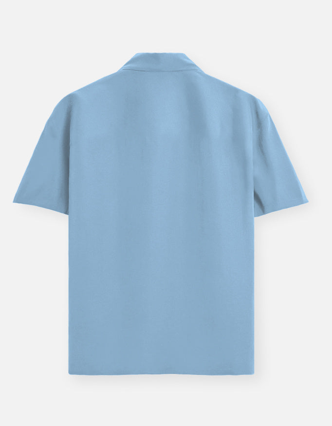 Color_BabyBlue. Premium unisex oversized button-down shirt with a wide, boxy fit and dropped shoulders. Made from breathable solid-colored cotton. Features a structured collar and longline hem, perfect for layered streetwear or minimalist smart-casual outfits.