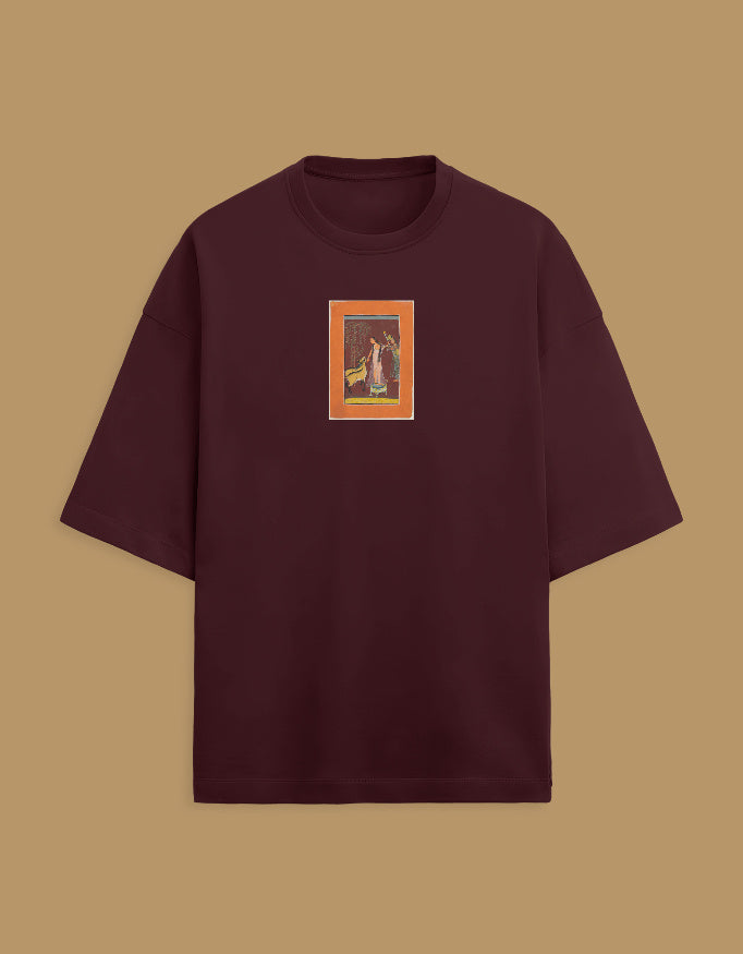 Color_Maroon. Oversized white streetwear t-shirt featuring a centered rectangular graphic of a classical South Asian miniature painting with an orange border. Dropped shoulders, heavyweight cotton, boxy fit.