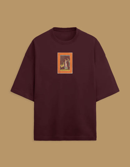 Color_Maroon. Oversized white streetwear t-shirt featuring a centered rectangular graphic of a classical South Asian miniature painting with an orange border. Dropped shoulders, heavyweight cotton, boxy fit.