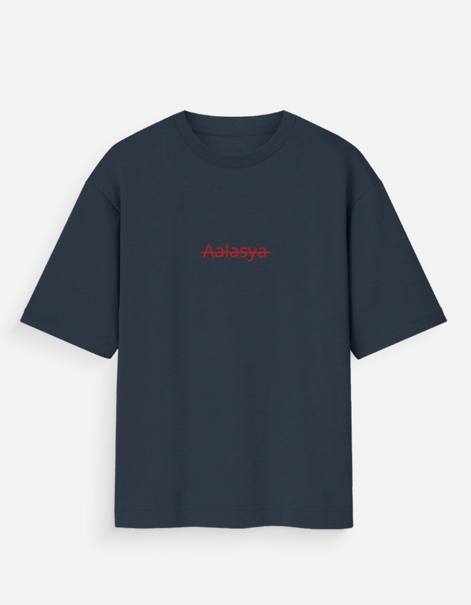 Navy Blue oversized unisex t-shirt featuring a centered, small graphic of the word "Aalasya" (laziness) written in red, stylized text with a red strikethrough line, signifying "No Laziness." Soft cotton, drop-shoulder, boxy casual apparel with ironic or statement typography.