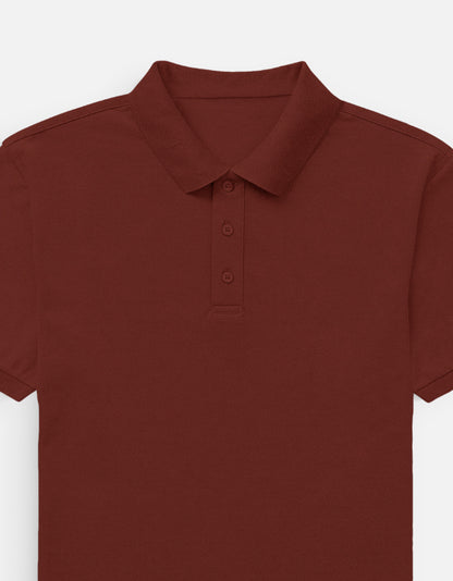 Color_BrickRed. Classic short-sleeved polo shirt with a structured ribbed collar and two-button placket. High-quality pique cotton fabric in a solid color, offering a sharp yet relaxed regular fit for a unisex smart-casual aesthetic.