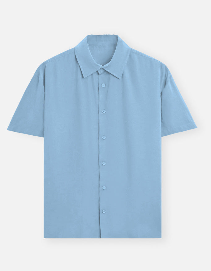 Color_BabyBlue. Premium unisex oversized button-down shirt with a wide, boxy fit and dropped shoulders. Made from breathable solid-colored cotton. Features a structured collar and longline hem, perfect for layered streetwear or minimalist smart-casual outfits.
