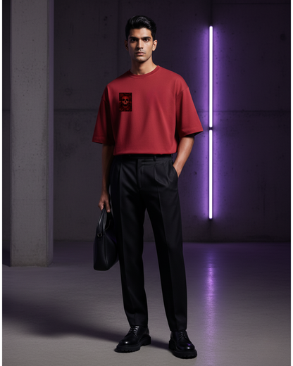 Chrimson Rebirth_Man wearing a red t-shirt and black pants standing in a dark room with a purple light.